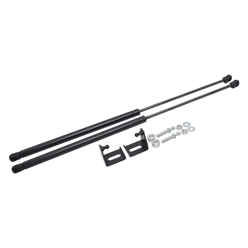 A pair of black gas spring struts (also known as gas lift supports or shock absorbers) with mounting brackets, bolts, nuts, and washers laid out on a white background. The struts are long and thin, likely for a car hood, trunk, or tailgate lift.