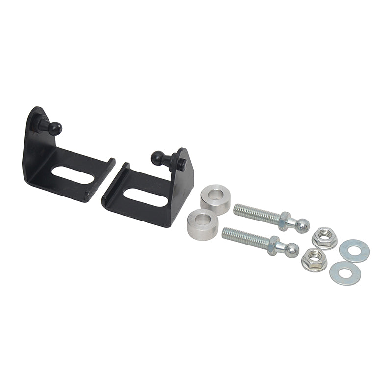 A close-up view of the mounting hardware for gas lift support struts. The image shows two black, L-shaped metal brackets, each featuring a ball stud for strut attachment and a slotted hole for mounting. Also included are two threaded ball studs (bolts), two silver spacer bushings, two nuts, and two washers, all laid out on a white background.