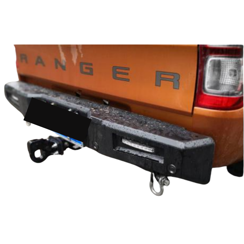 A close-up rear view of an orange Ford Ranger pickup truck with an aftermarket, heavy-duty, matte black steel rear bumper installed.
The bumper features a rugged, angular design, an integrated horizontal LED light on the visible right side, and a D-ring shackle mounted on the bottom right. A tow hitch assembly is visible beneath the bumper on the left, and the tailgate prominently displays the dark lettering "RANGER". The image is cropped tightly around the bumper and tailgate.