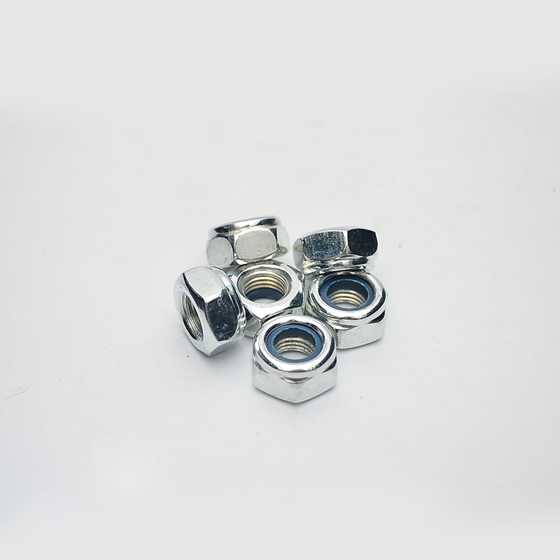 A close-up pile of six shiny, chrome or zinc-plated metallic hex nuts, which appear to be nylon insert lock nuts (nylock nuts), against a white background. The blue nylon locking insert is visible inside the threads of the nuts.