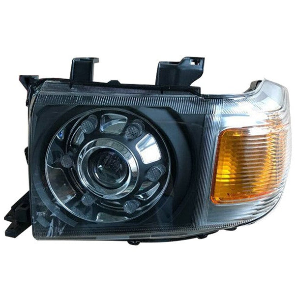 A product photograph of a single aftermarket LED headlight assembly designed to fit a rectangular housing, likely for a Toyota Land Cruiser 70 Series.
The assembly features a clear plastic lens and a black inner housing.
The right side contains the amber turn signal/indicator, which is ribbed and slightly curved at the edge.
The main headlight section on the left is round and features a central chrome projector lens surrounded by a chrome ring with eight distinct reflector segments, which would house LED.