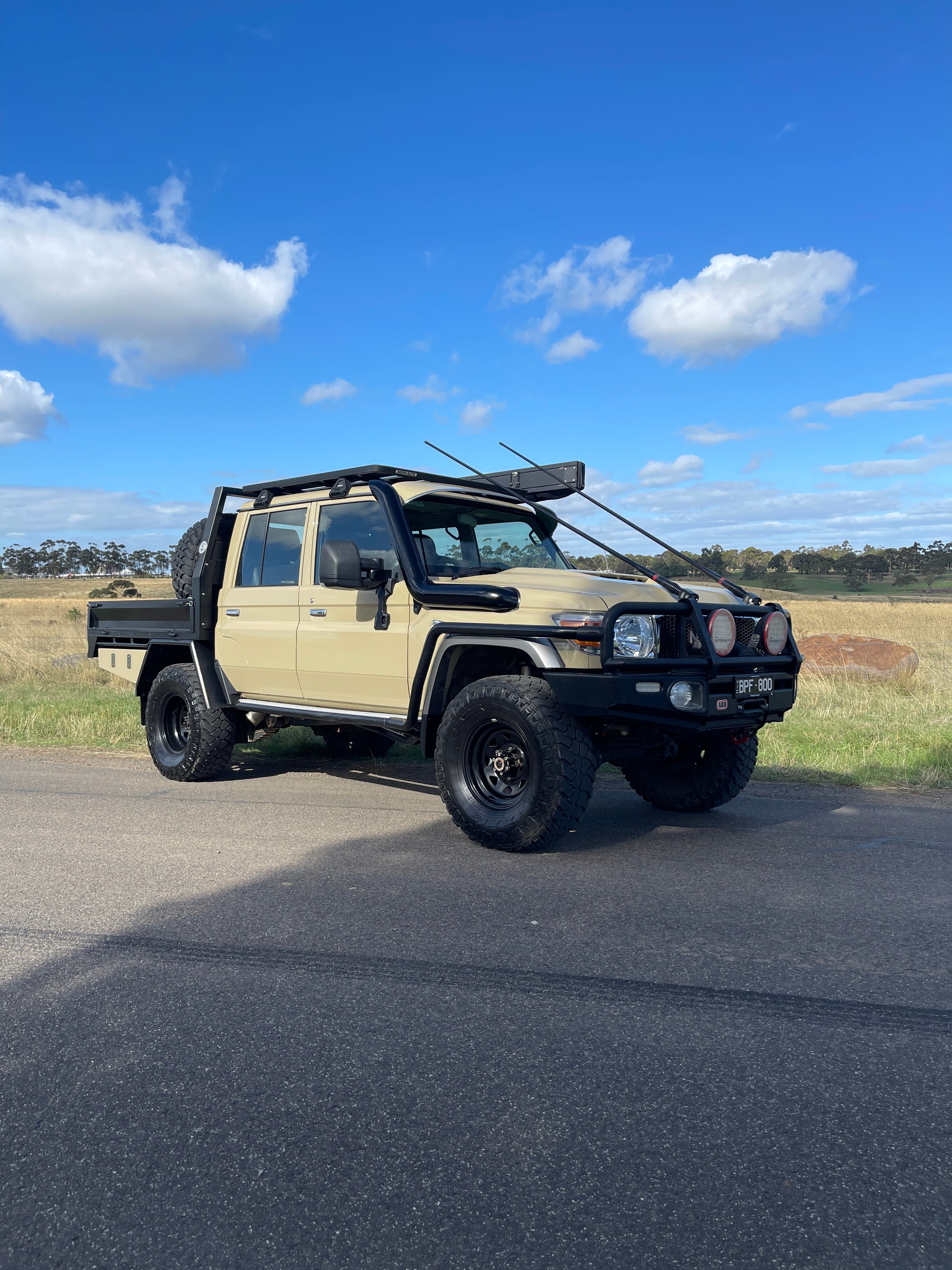 Sand Toyota LandCruiser 79 single cab with Canna Fabrication 5 inch twin snorkels — front three-quarter view
