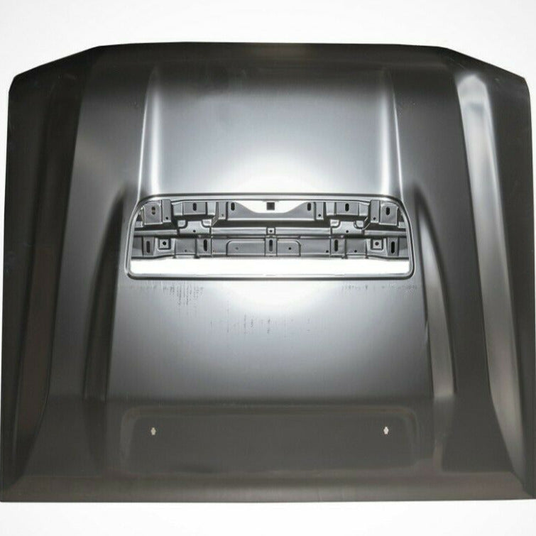 A flat, overhead view of a dark grey or black metallic car hood. The hood features two parallel raised lines running from front to back and a large, rectangular opening or scoop cutout near the center, designed for a hood scoop or vent grille. The cutout shows the unfinished metal structure beneath the opening. The hood surface has a semi-gloss finish and is isolated against a white background.