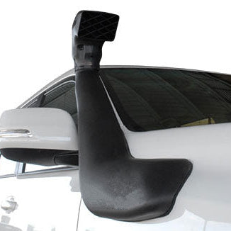 A close-up side view of a black automotive snorkel attached to the white body of a vehicle near the driver's side A-pillar and fender. The snorkel curves upward, and its top, which features a square, grille-like air intake, extends just above the roofline. The white side mirror is visible in the background.